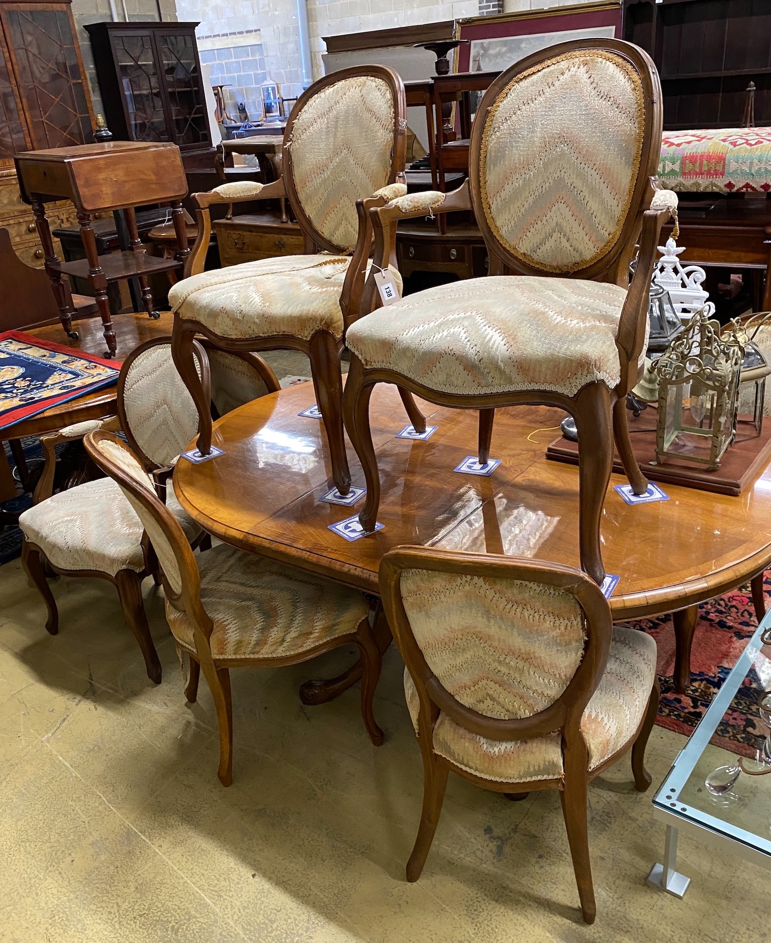A Queen Anne Revival oval walnut extending dining table, length 162cm extended, one spare leaf, width 120cm, height 73cm together with eight Louis XVI style upholstered elbow chairs